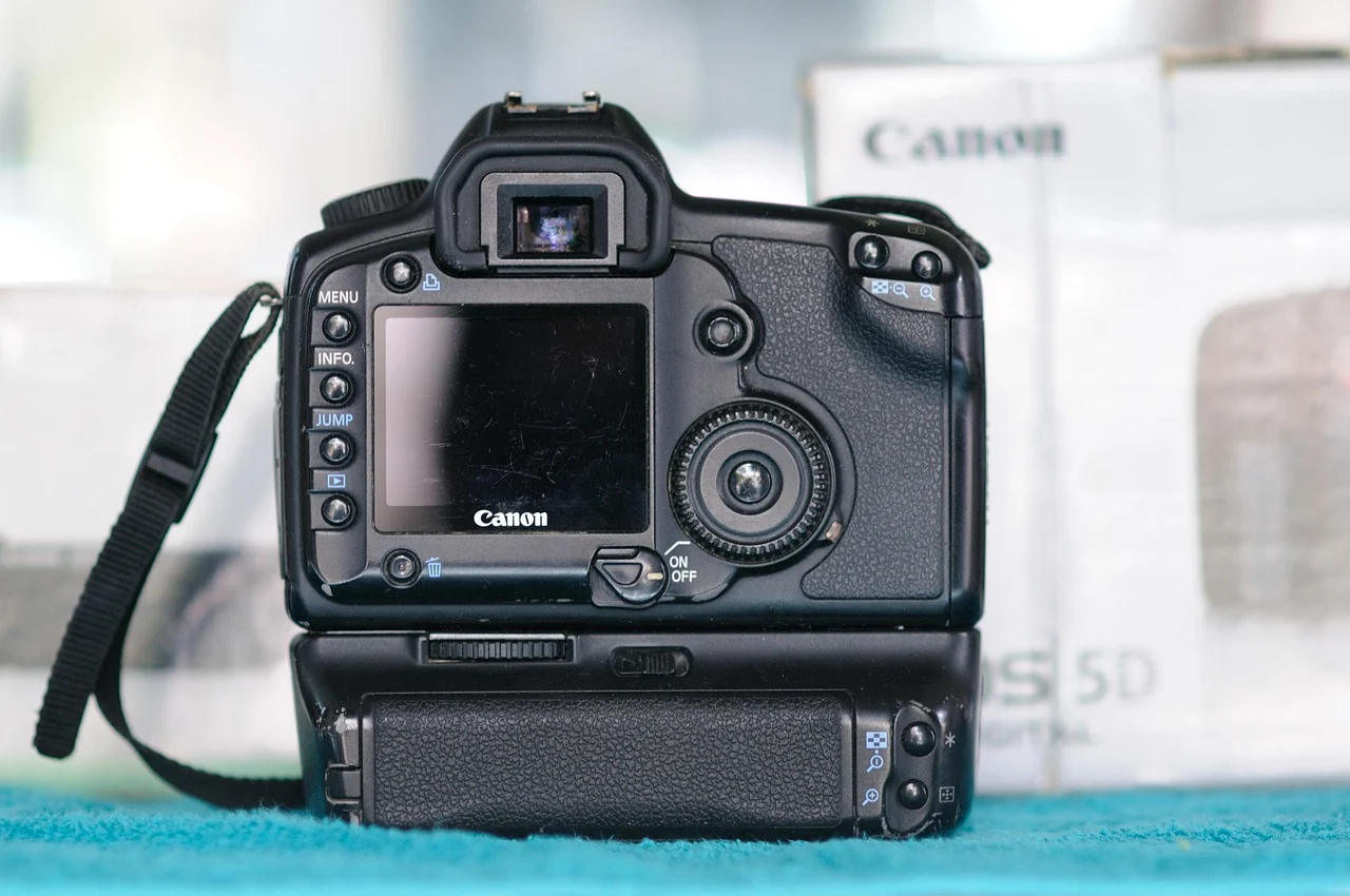 Rear view of a digital camera and battery grip on a blue surface